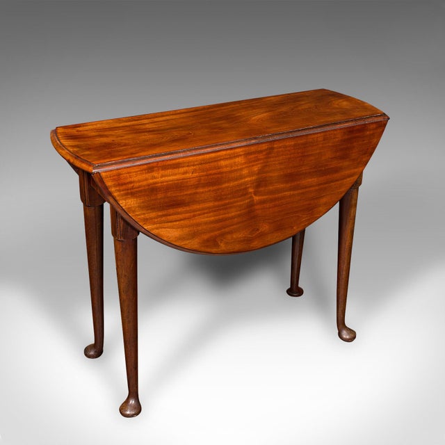 This is an antique 4 seat drop leaf supper table. An English, Cuban Mahogany extending gate leg serving table, dating to...