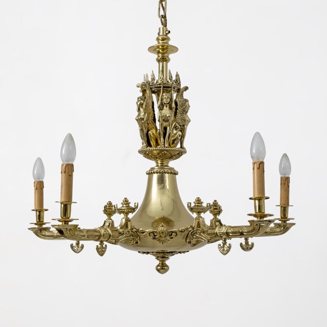 Monumental chandelier featuring a sculptural central body decorated with winged female figures in the round, inspired by...