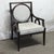 Dark wood tone framed chair with circular carvings on the side and gray upholstery. There is some wear and fraying in the...