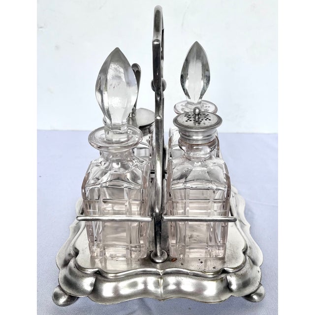 Produced in England in the late 1800s. This is an antique silver-plated caster or cruet set, likely from the Victorian...