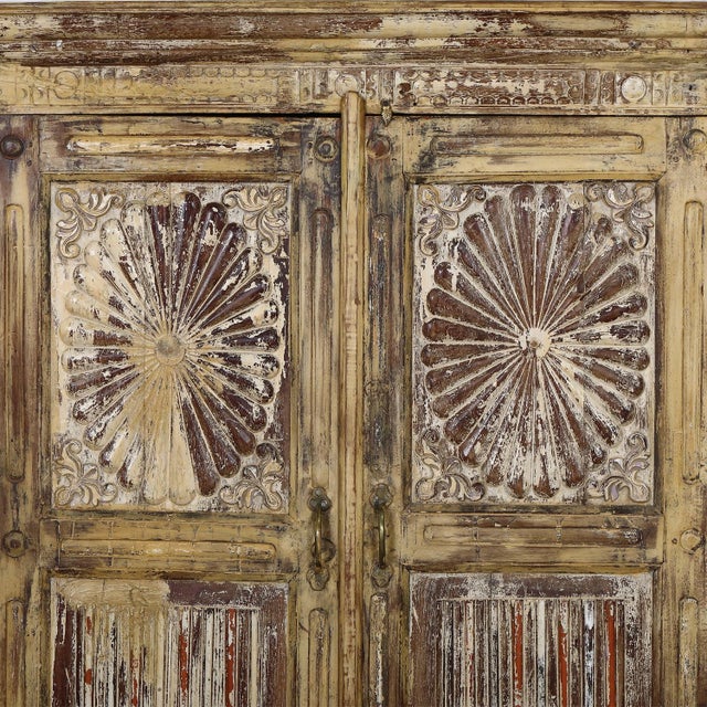Antique Indian Painted Teakwood Armoire, in its old faded yellow and red paint decoration, the doors panels carved with...