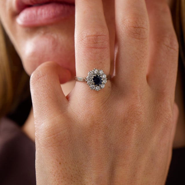 This elegant vintage sapphire and diamond cluster ring is a beautifully balanced 1980’s design, centered by an oval cut...