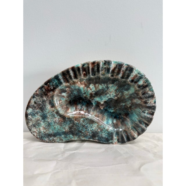 A striking mid-century studio pottery ashtray by Don Wright, featuring a bold reactive glaze in turquoise, deep brown, and...
