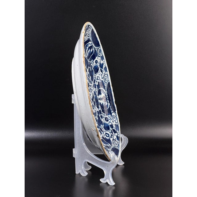 This is an authentic 18th century Dutch Delft charger, hand-painted in cobalt blue on a white tin-glazed earthenware body....