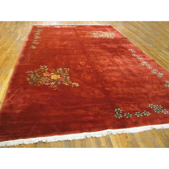 The warm rust red field runs out to all four sides and features a diagonally balanced design of corner rosette chains...