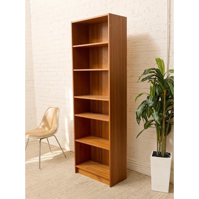 A handsome vintage Danish Modern bookcase crafted in warm teak with a beautifully streamlined, architectural profile. The...