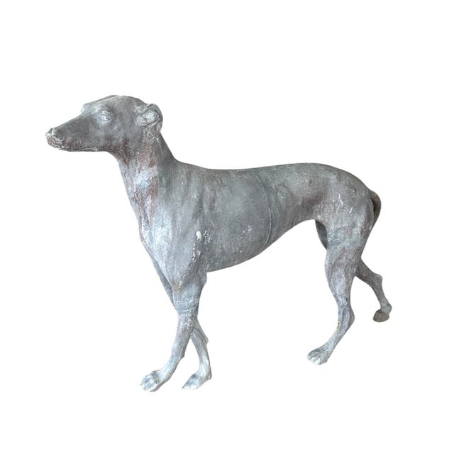 A charming, antique cast lead garden statue. Features a standing greyhound or whippet in beautifully patinated, cast lead....