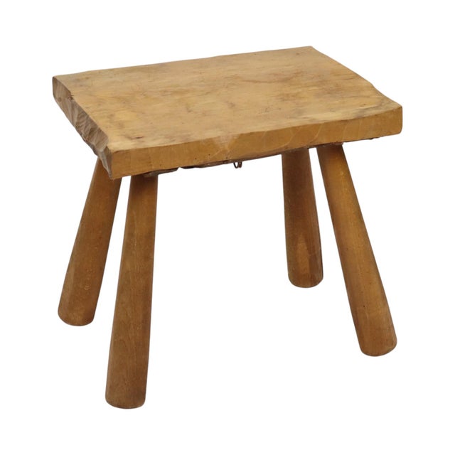 Rustic antique stool with a small hook beneath the seat—a vintage milking stool crafted from solid wood, originating from...
