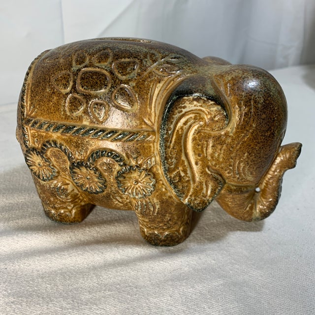 This vintage Paul Marshall mid-century ceramic elephant coin bank features a rich, speckled brown glaze and intricate...