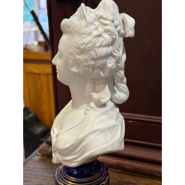 Beautiful antique bust of Marie Antoinette. Made of bisque porcelain and done in the style of Sevres, she sits on a cobalt...