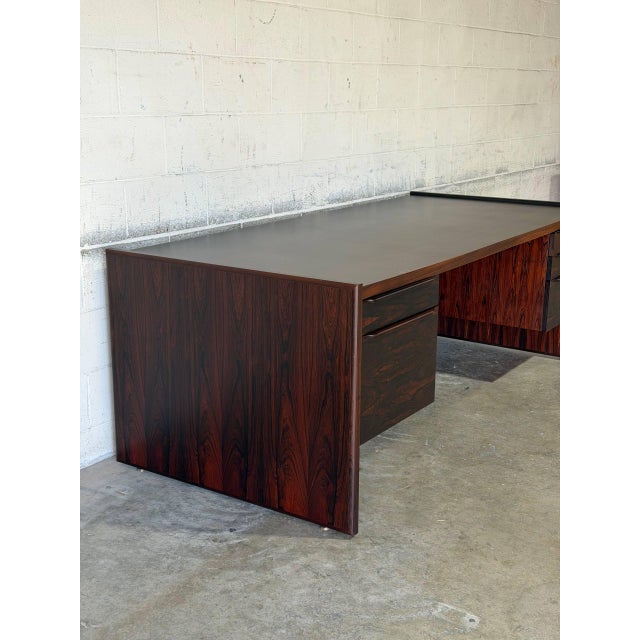 This executive desk commands attention with its substantial slab-sided form and expansive workspace. The asymmetrical...