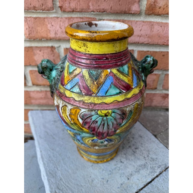 This vintage Italian Majolica terracotta urn (or vase) showcases vibrant, hand-painted designs and distinctive lion head...