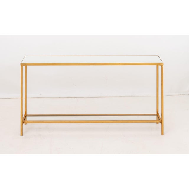 Narrow Gilded Iron Console Table, with beveled mirrored top and undertier with clear glass insert. 30.75" H x 59.75" W x...