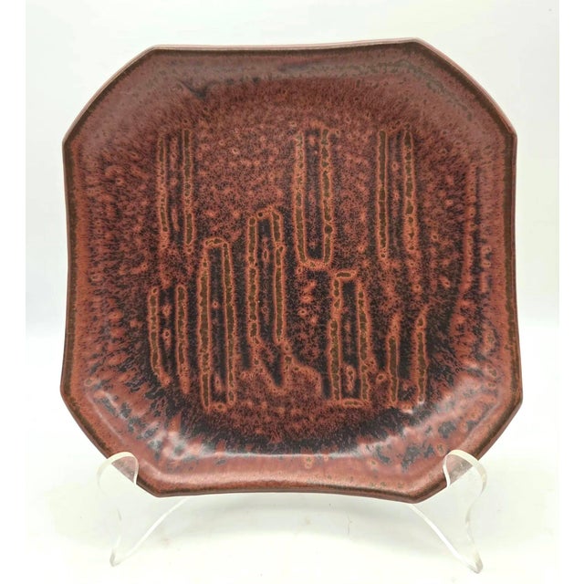 Offered is a mid 20th Century modern art pottery brown and brick-colored decorative plate with geometric embossed or...