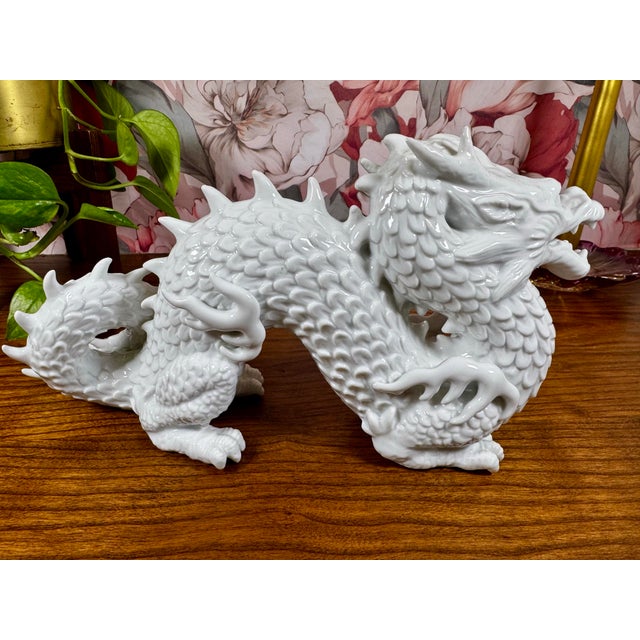 A vintage white glazed ceramic dragon sculpture featuring expressive movement and finely detailed scales. Made in Mexico,...