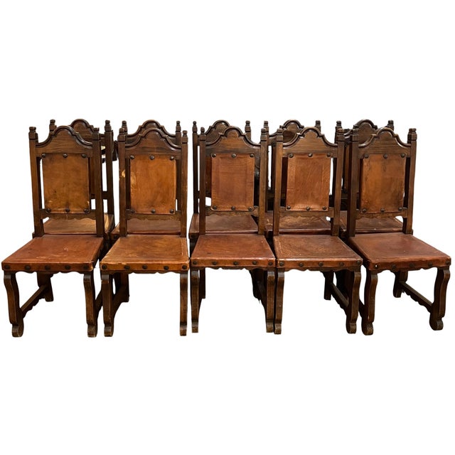 A Beautiful Set of Spanish Style Chairs. Two Arm Chairs and 10 Side Chairs featuring leather Upholstry, Carved Wood and...