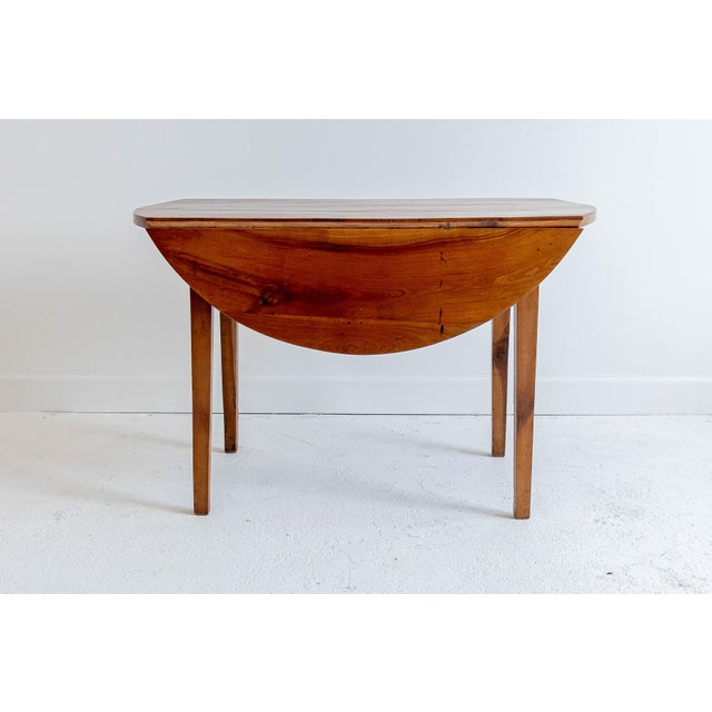 This darling walnut table is slightly oval in shape when the leaves are extended and becomes a rectangle when the leaves...