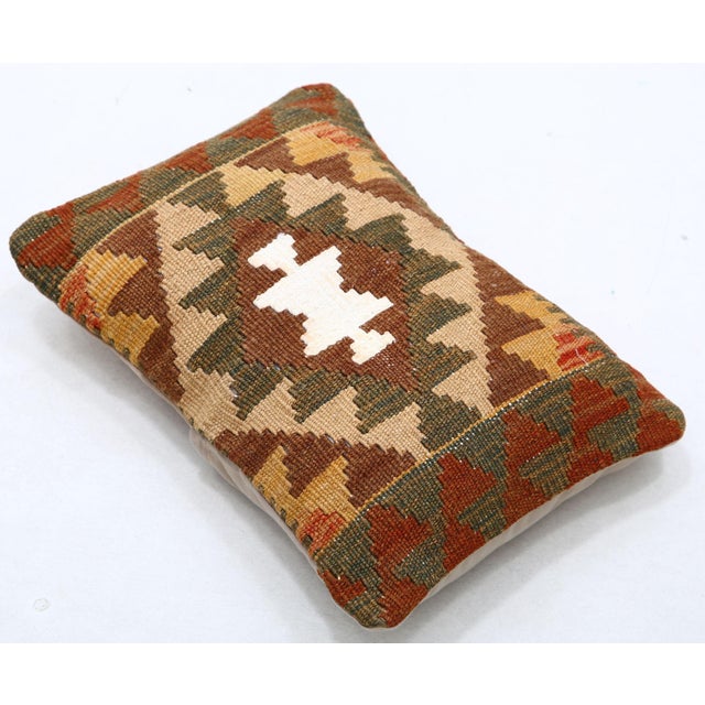 A one-of-a-kind handwoven Afghan wool kilim lumbar pillow featuring concentric diamond with a hooked center. Cut and sewn...