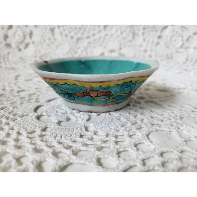 A small vintage china pottery bowl with a floral motif in turquoise, pink and yellow. Marked 'China' and measuring 4 ½”...