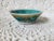 A small vintage china pottery bowl with a floral motif in turquoise, pink and yellow. Marked 'China' and measuring 4 ½”...