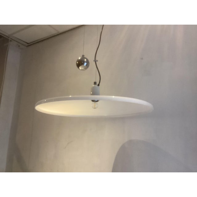 White Guzzini Pendant designed by Franco Bresciani in the seventies. This Italian Guzzini hanging lamp gives a very...