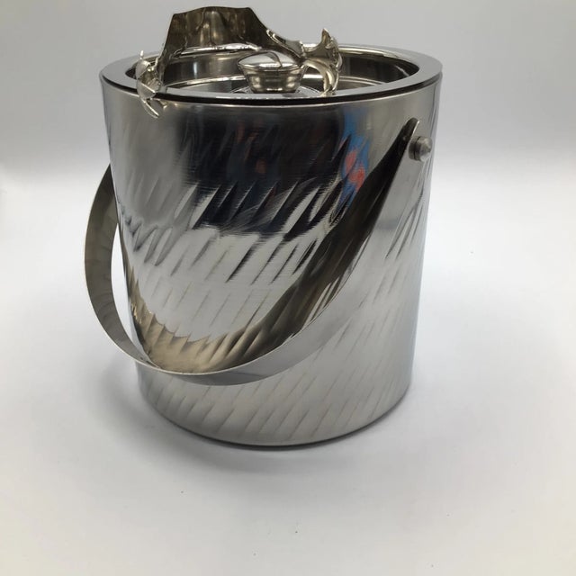 Here is a handled ice bucket made of stainless steel with a double wall thickness and very snug fitting lid. It has a...