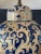 Vintage deep blue and gold scroll design table lamp. Ceramic lamp sits on a wooden base with an off white shade. Shade...