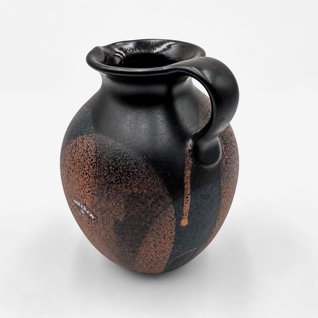 This ceramic pitcher, signed Steuler Keramik, a German manufacturer, features a generously rounded silhouette, extending...