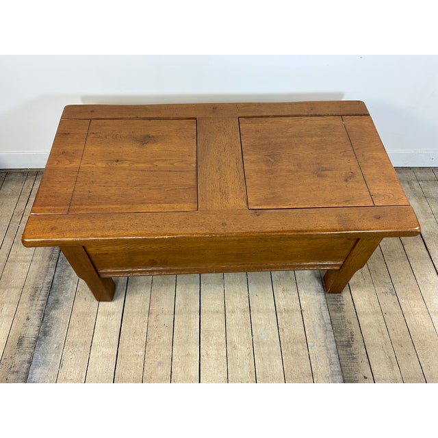 Solid oak coffee table with a top that opens to reveal a storage compartment, one of which is partially divided. A high-...
