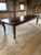 Impressive in scale and full of hand hewn character, a gigantic reclaimed barn wood farm table having cabriole legs and...