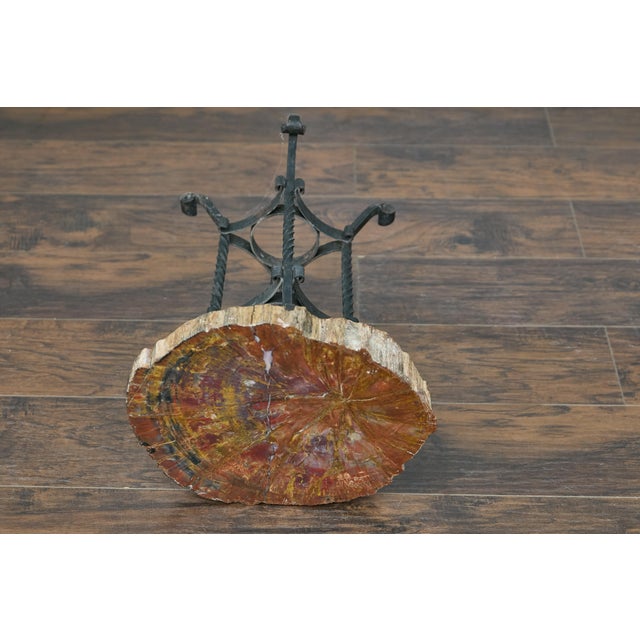A French Turn of the Century petrified wood table side table from circa 1900 with wrought iron quadripod base. This French...