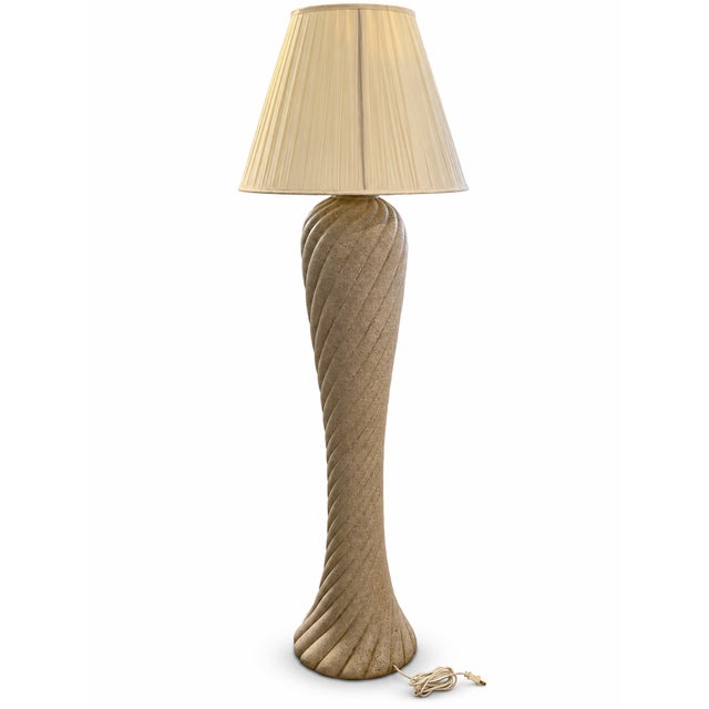 A sculptural floor lamp featuring deep spiral ribs, a flared circular base, and a warm beige stone-look finish. Its...