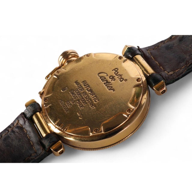 Cartier Pasha 1035 automatic watch in 18K yellow gold featuring a 35mm round case with ivory dial, bold black Roman...