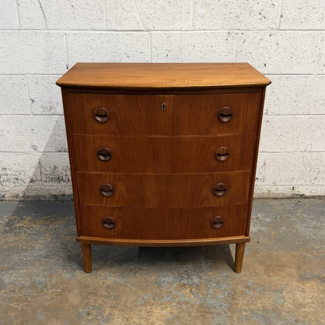 This Danish teak chest has a great mid-century look, with a softly curved front, rounded legs, and distinctive circular...