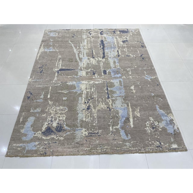 Clara Stylish Gray Hand Knotted Wool Rug, Country of Origin: India. This contemporary piece showcases a dynamic abstract...