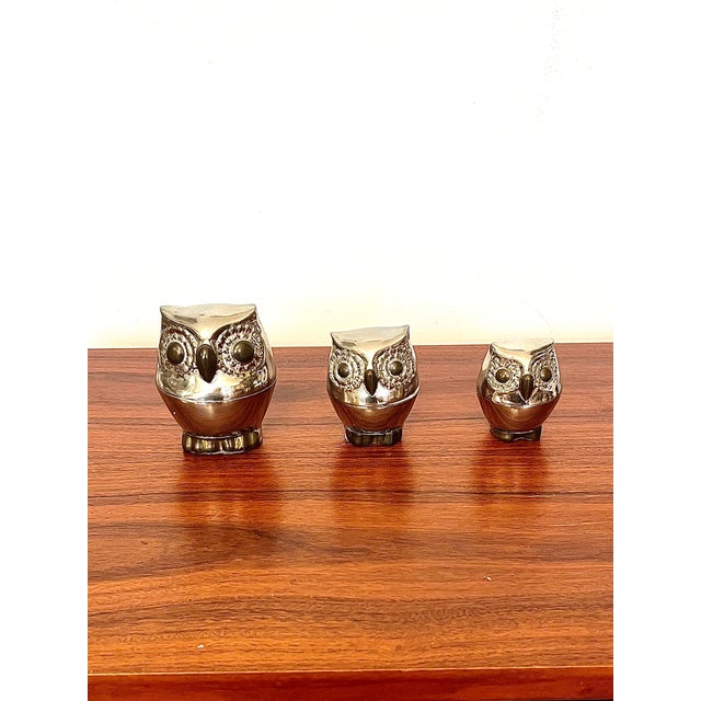A truly charming trio of sculptural owl-shaped boxes in silver-plated metal, whose decorative presence far surpasses their...