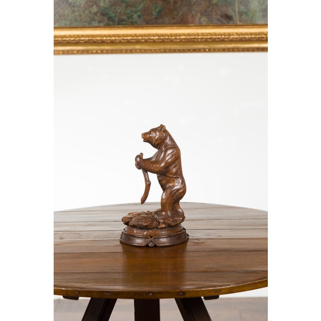 A Black Forest carved wooden sculpture from the late 19th century, depicting a bear standing on a circular base. Created...
