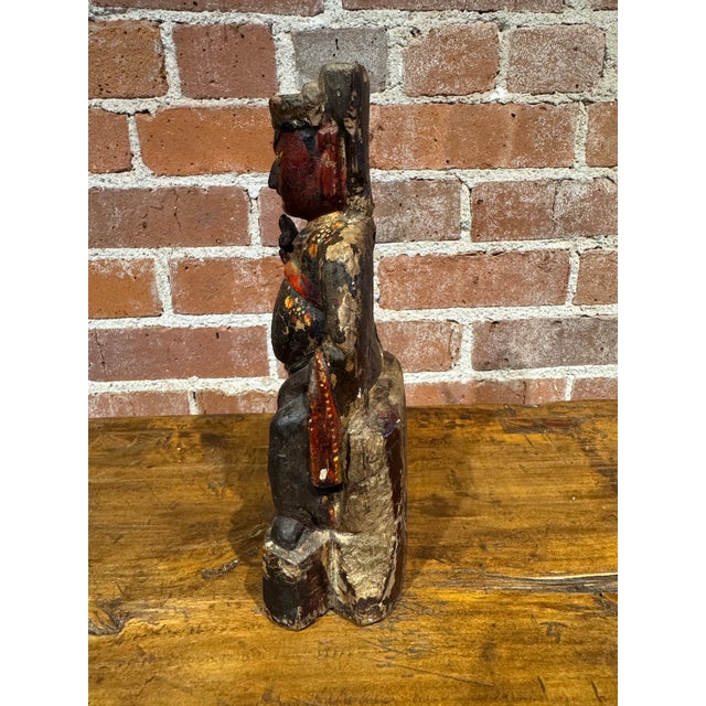 Fine wood carved antique Chinese statue of a warrior or ancestor figure seated in a traditional pose. The wear and loss of...