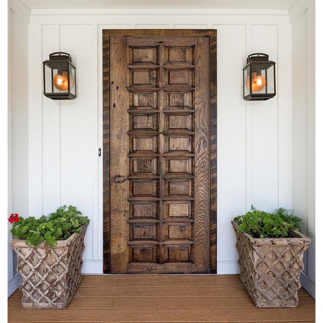 Crafted from reclaimed solid wood, this Spanish Revival-style entry door features a tightly aligned raised-panel grid that...