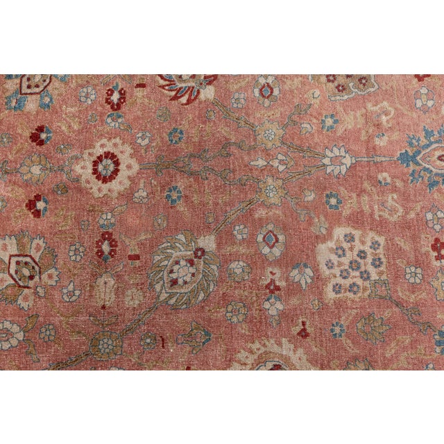 This Persian Tabriz hand-knotted wool rug dating back to circa 1930 showcases a traditional dense floral design with...
