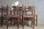 A charming set of five antique wooden chairs, exuding warmth and authenticity. The backrests are composed of gently...