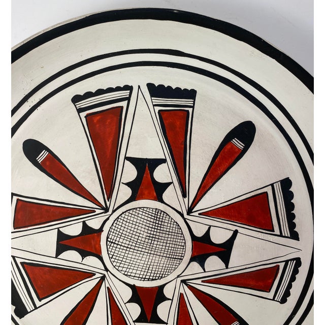 A modernist decorative plate / wall decoration / centerpiece with strong graphic decor. Undertones of bone white glaze...