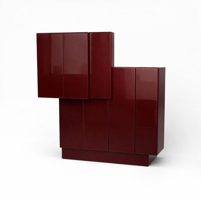 Large postmodern geometric cabinet with a sculptural stepped silhouette and deep oxblood lacquer finish. The cabinet is...