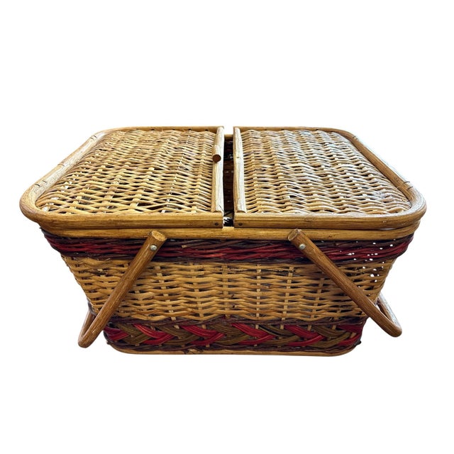 Charming vintage wicker picnic basket featuring decorative grape clusters, woven red and natural accents, dual folding...