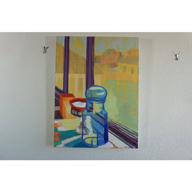 This is an expressive interior/exterior view with objects on a windowsill looking out to the suburban landscape. It...