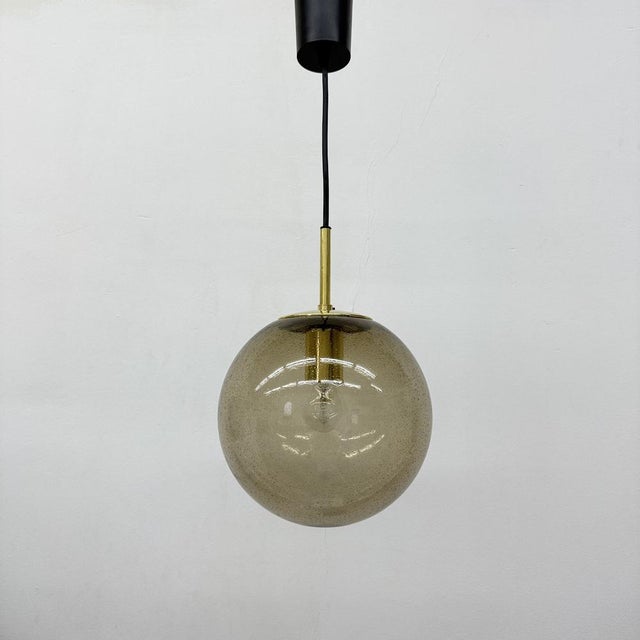 Brass and Smoked Glass Ball Pendant from Limburg Glashütte, 1970s, in Very Good conditions. Designed 1970 to 1979 Up to...