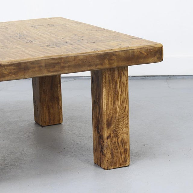 This large, square coffee table from the 1960s is crafted in the Brutalist style and made of solid oak. The wood shows...
