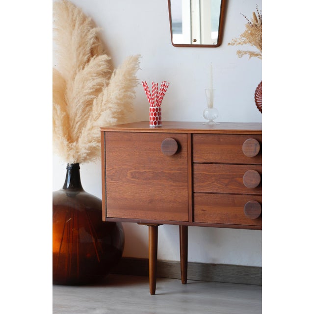 This small Scandinavian sapele sideboard was created in the 1960s by the English company Times Furnishing. It strikes a...