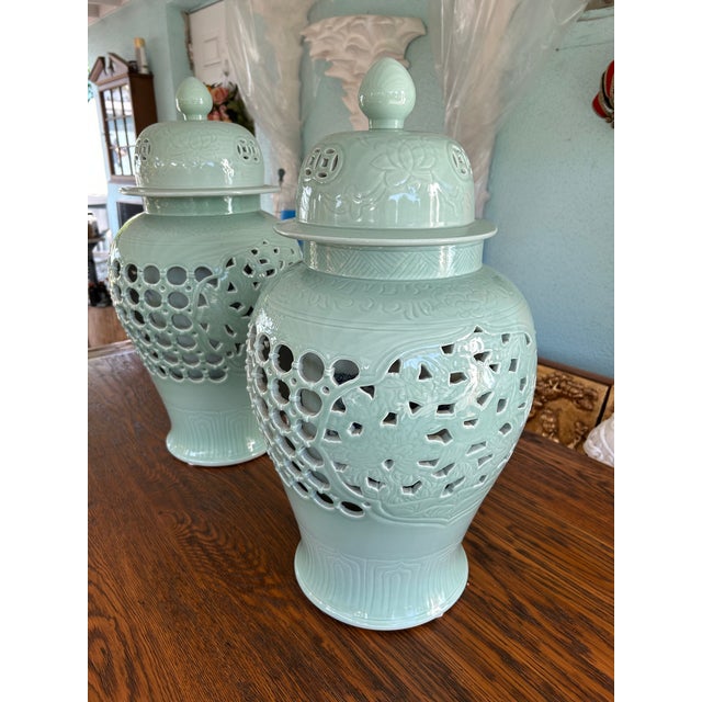 An impressive pair of large Chinese-style celadon porcelain covered jars, each measuring H 23.5'' x W 12'' x D12'' The...