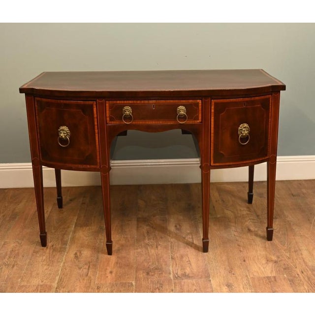 Elegant Sheraton style mahogany sideboard, dating to the early 20th century, circa 1900-1920 The sideboard features a...